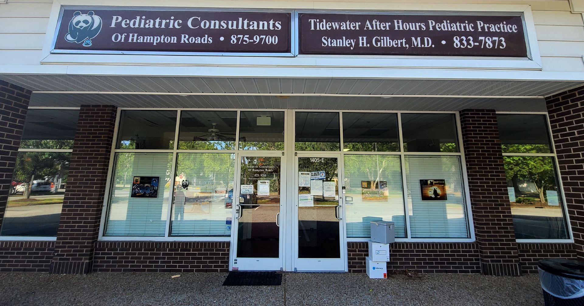 Exterior of Pediatric Consultants office building. Signage indicates the name and contact info. Large glass windows.