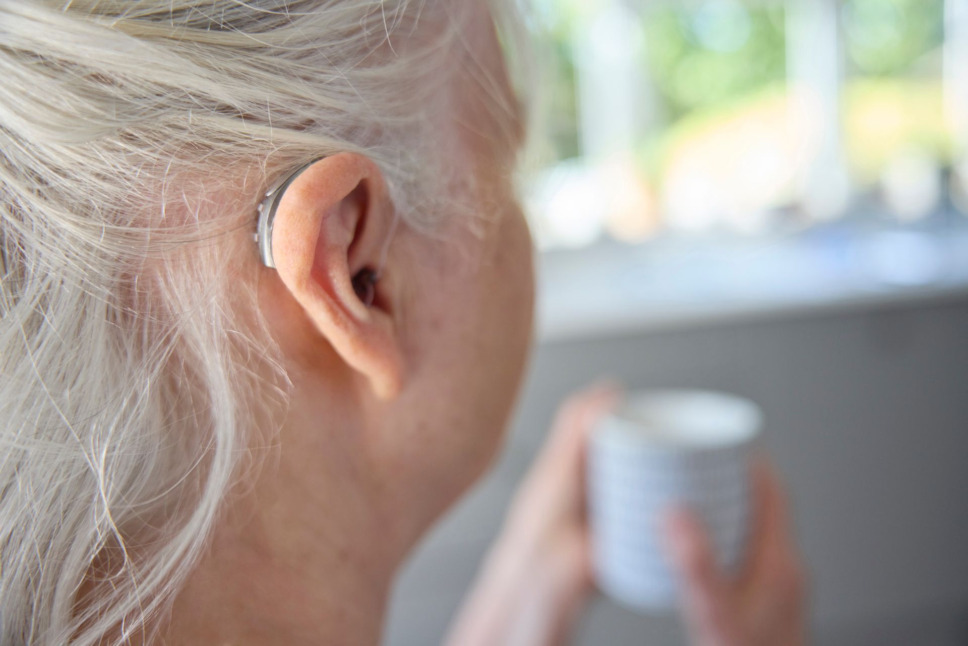 Closeup shot of senior adult woman with a cochlear implant. Closeup shot of senior adult woman with a cochlear implant.