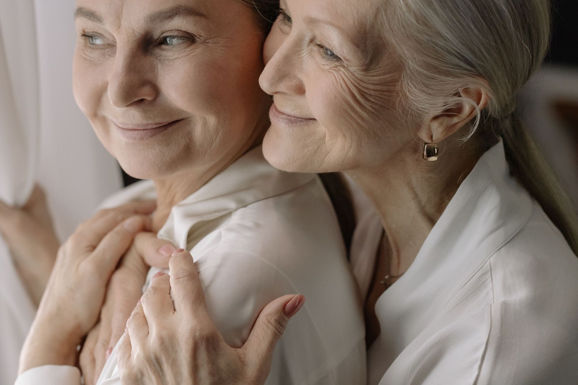 Woman With Gray Hair Embracing Elderly Woman
