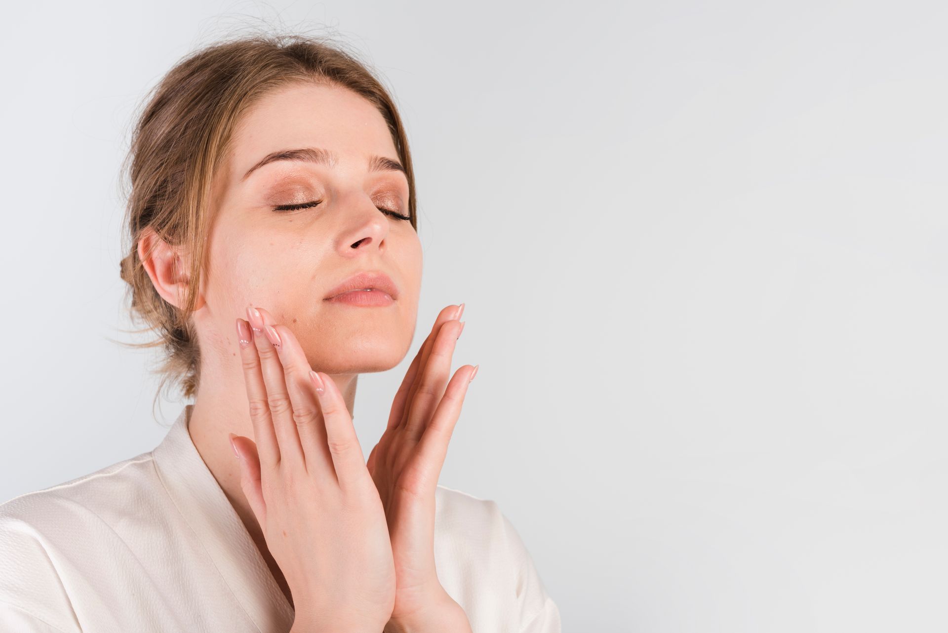 Woman touching her smooth face after microneedling result.