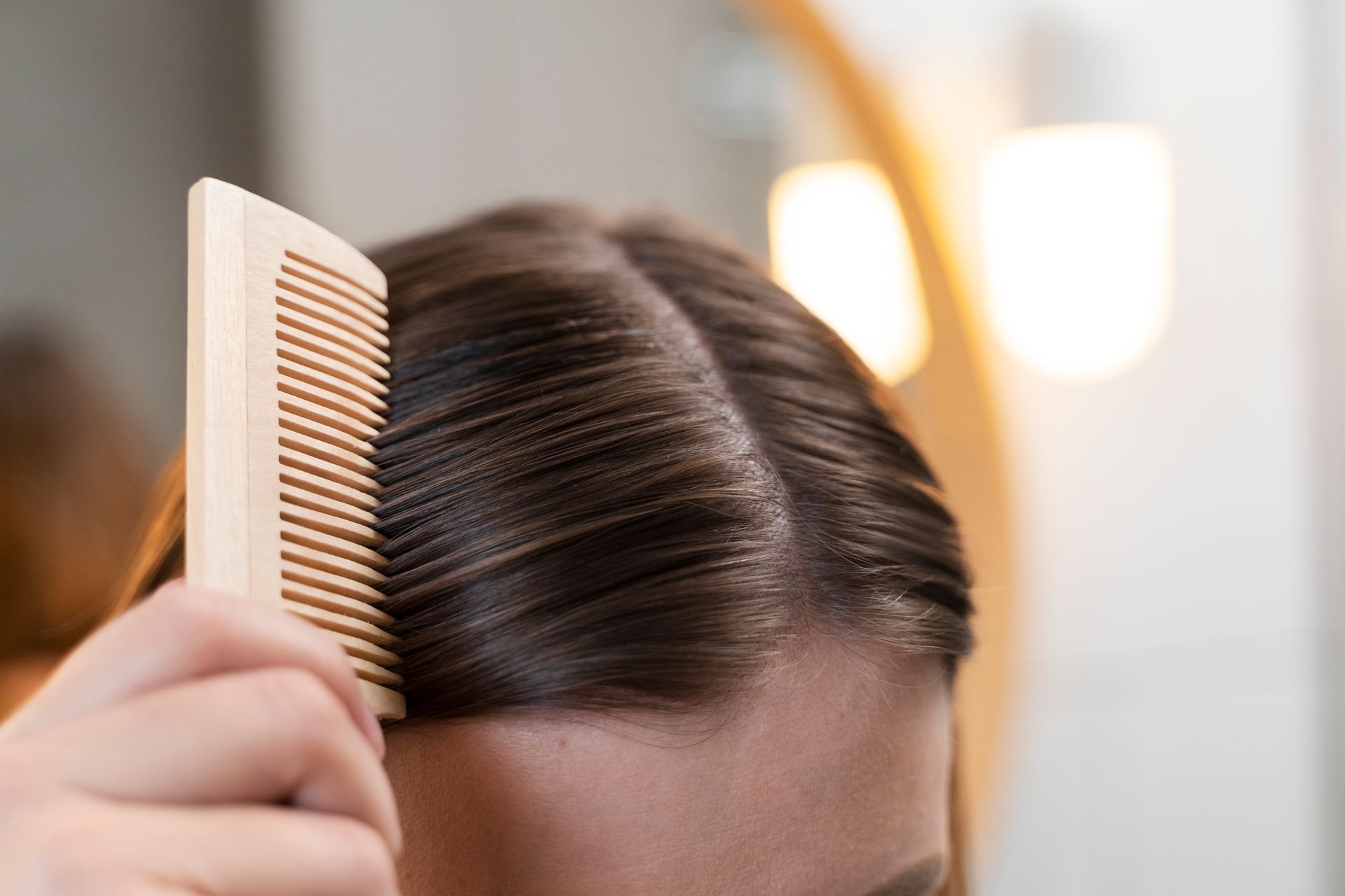 a woman is combing her hair with a wooden comb .