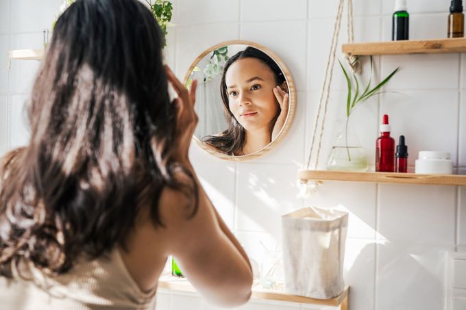 young woman looking in the mirror