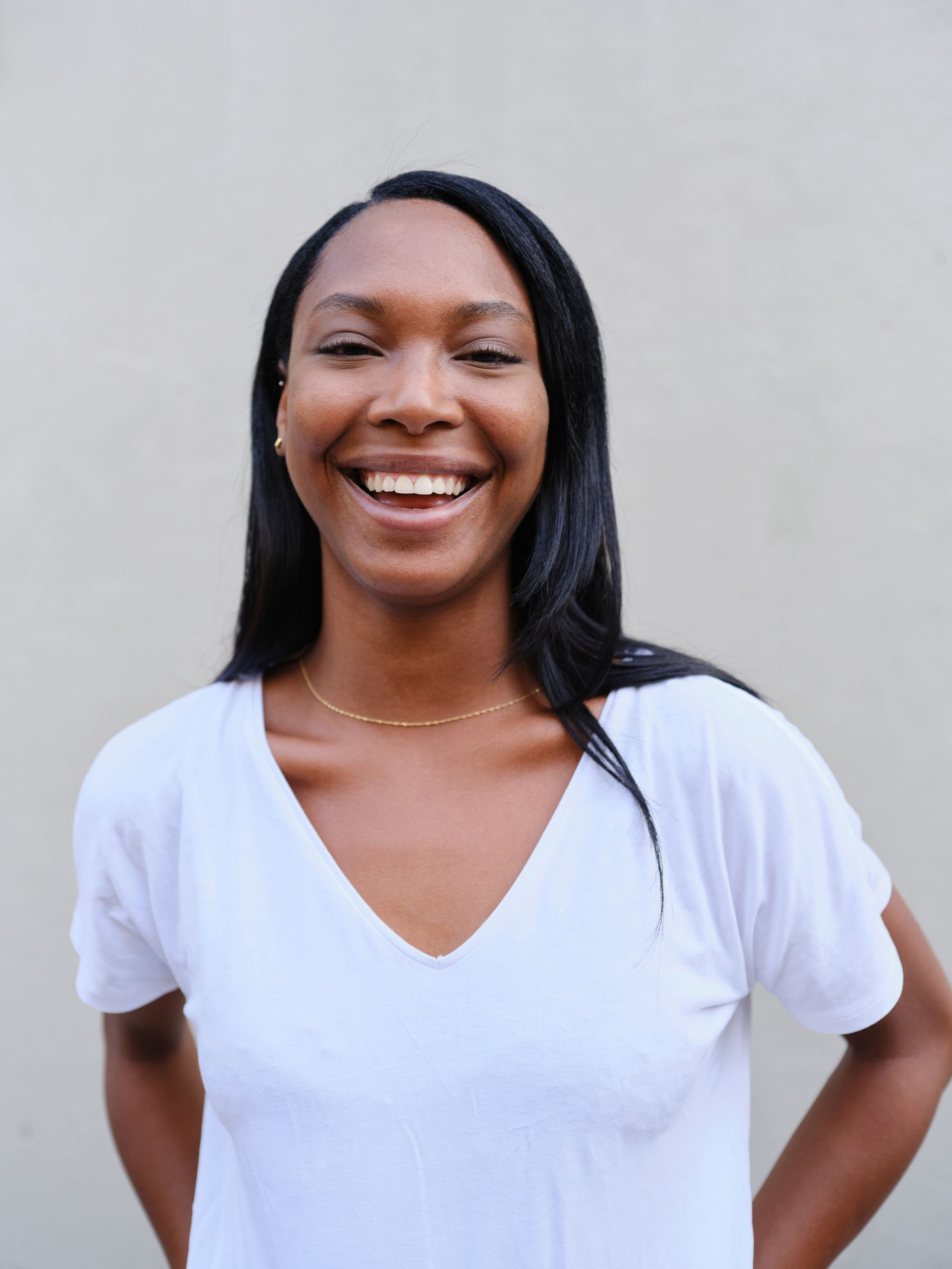 cheerful young african woman smiling in white tshirt