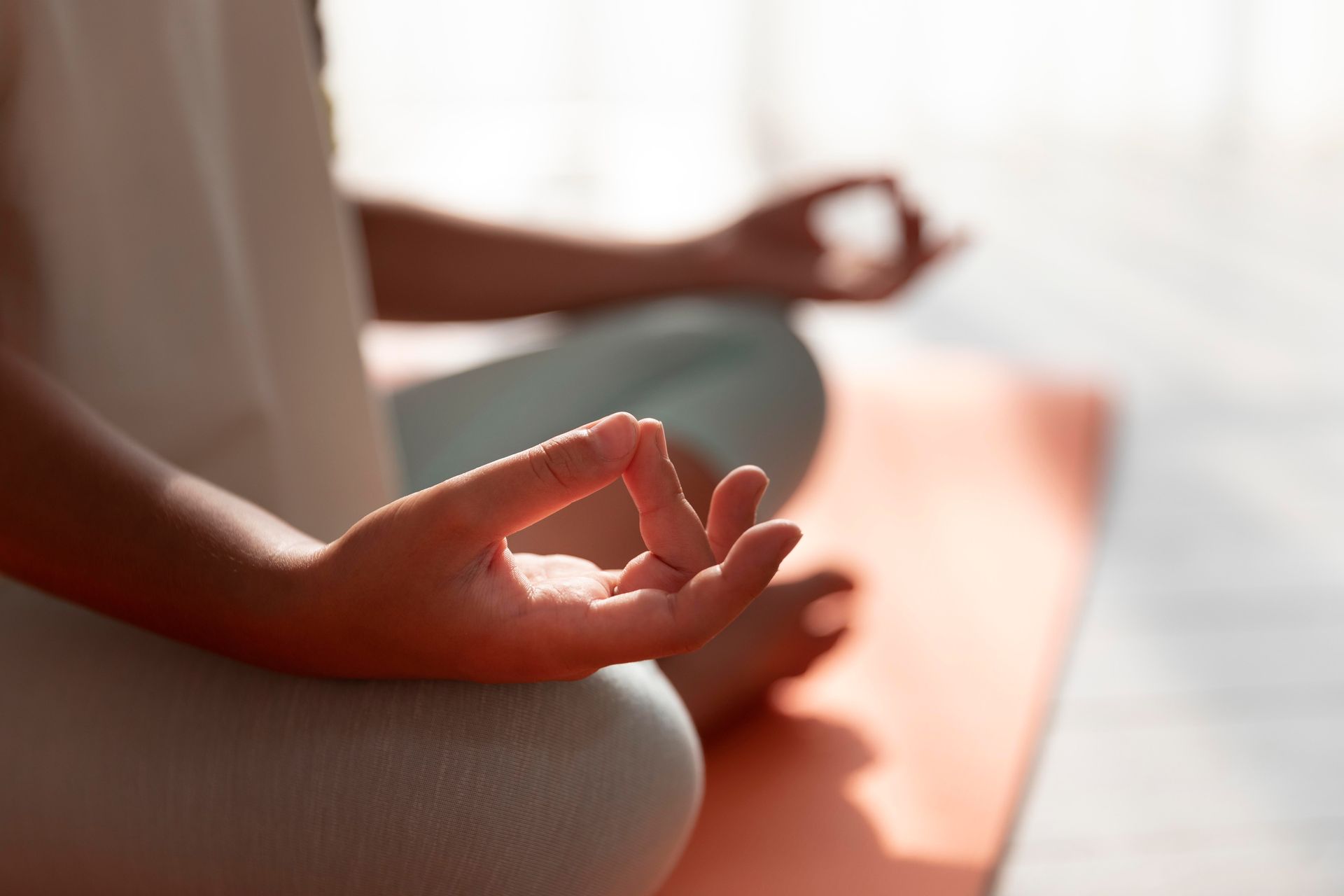 a person sitting on a yoga mat with their hands in a lotus position