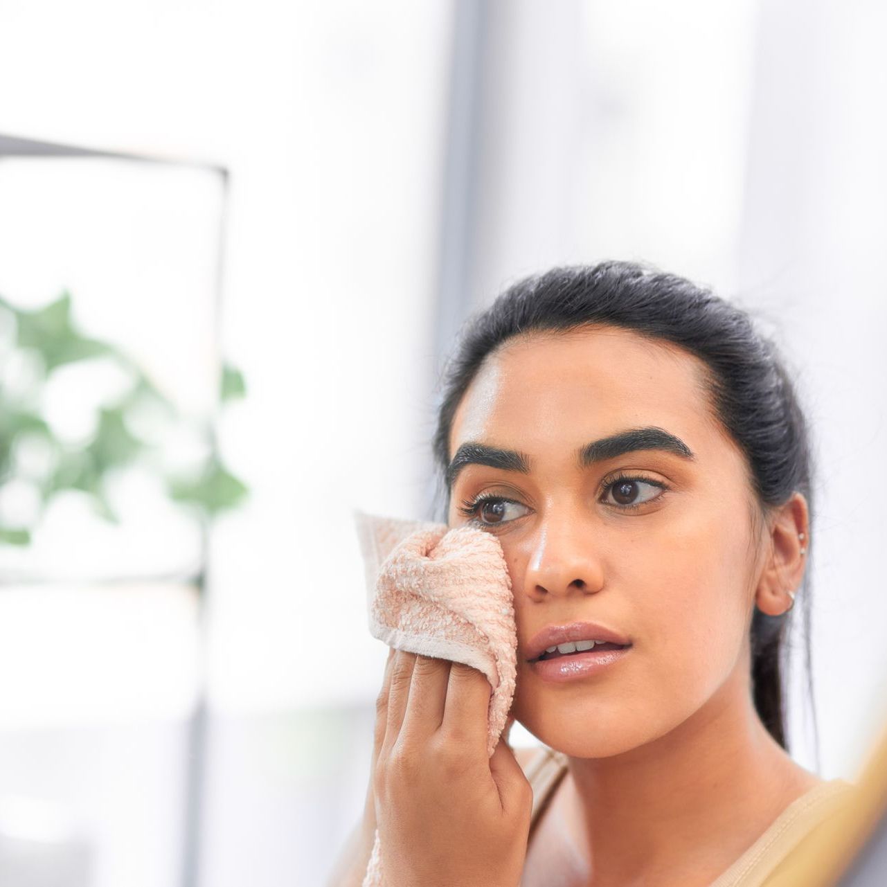 woman wiping her face with hand towel