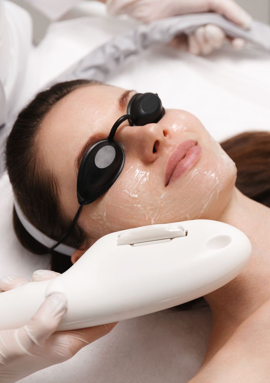A woman is getting a laser treatment on her face.