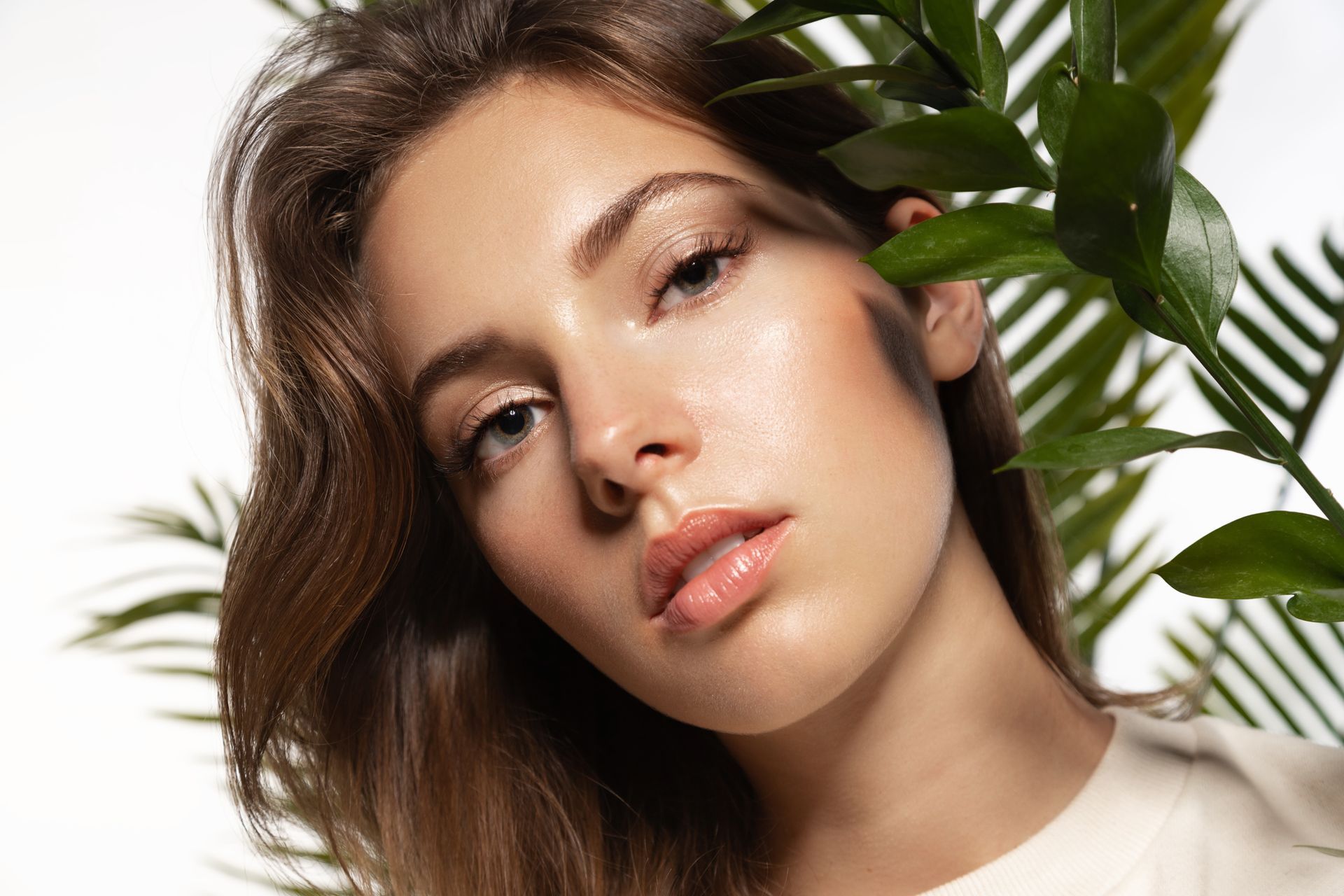 A close up of a woman 's face with a palm tree in the background.