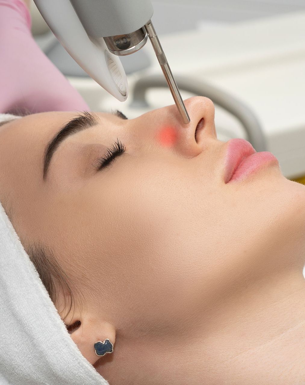A woman is getting a laser treatment on her face