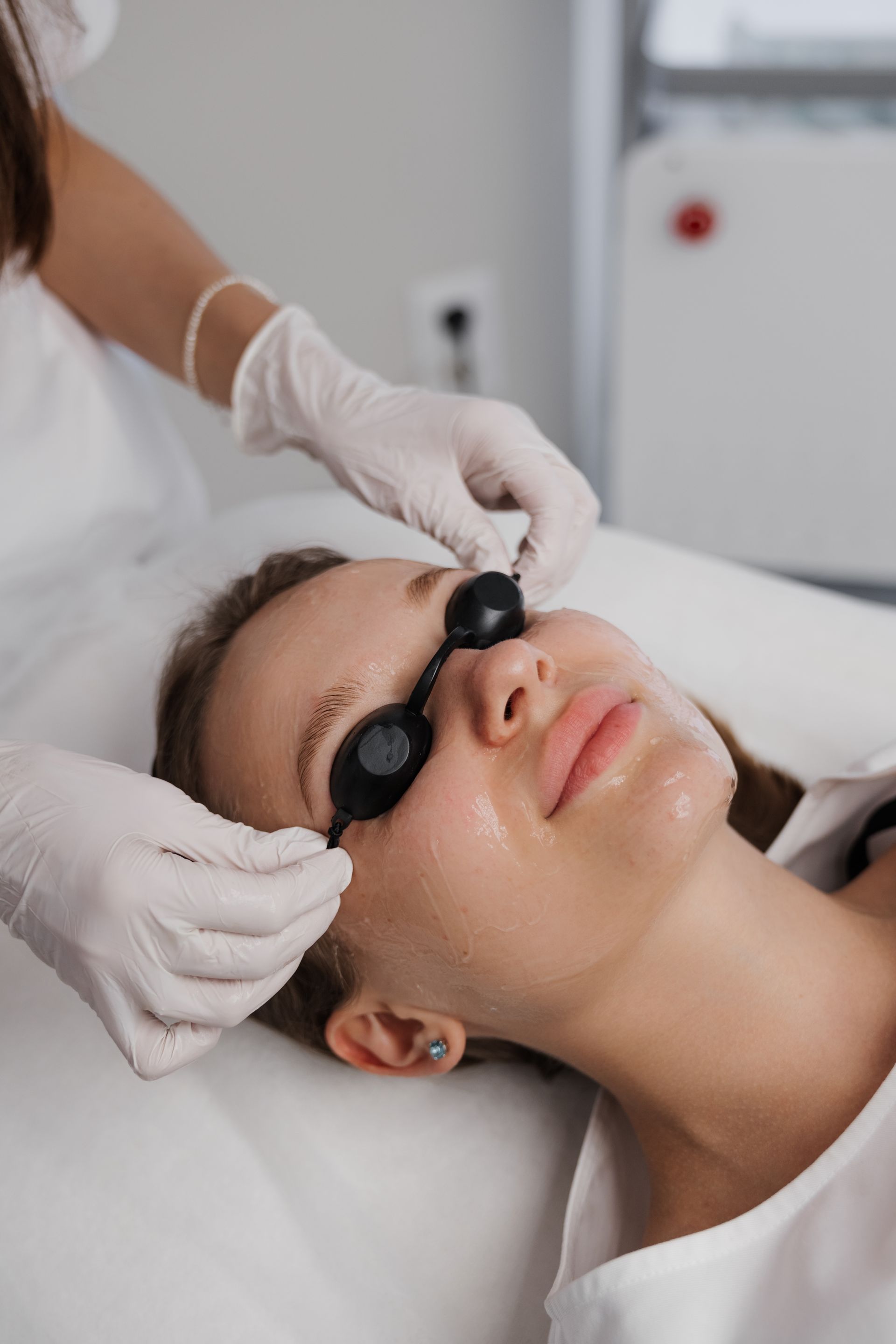 A woman is getting a laser treatment on her face.