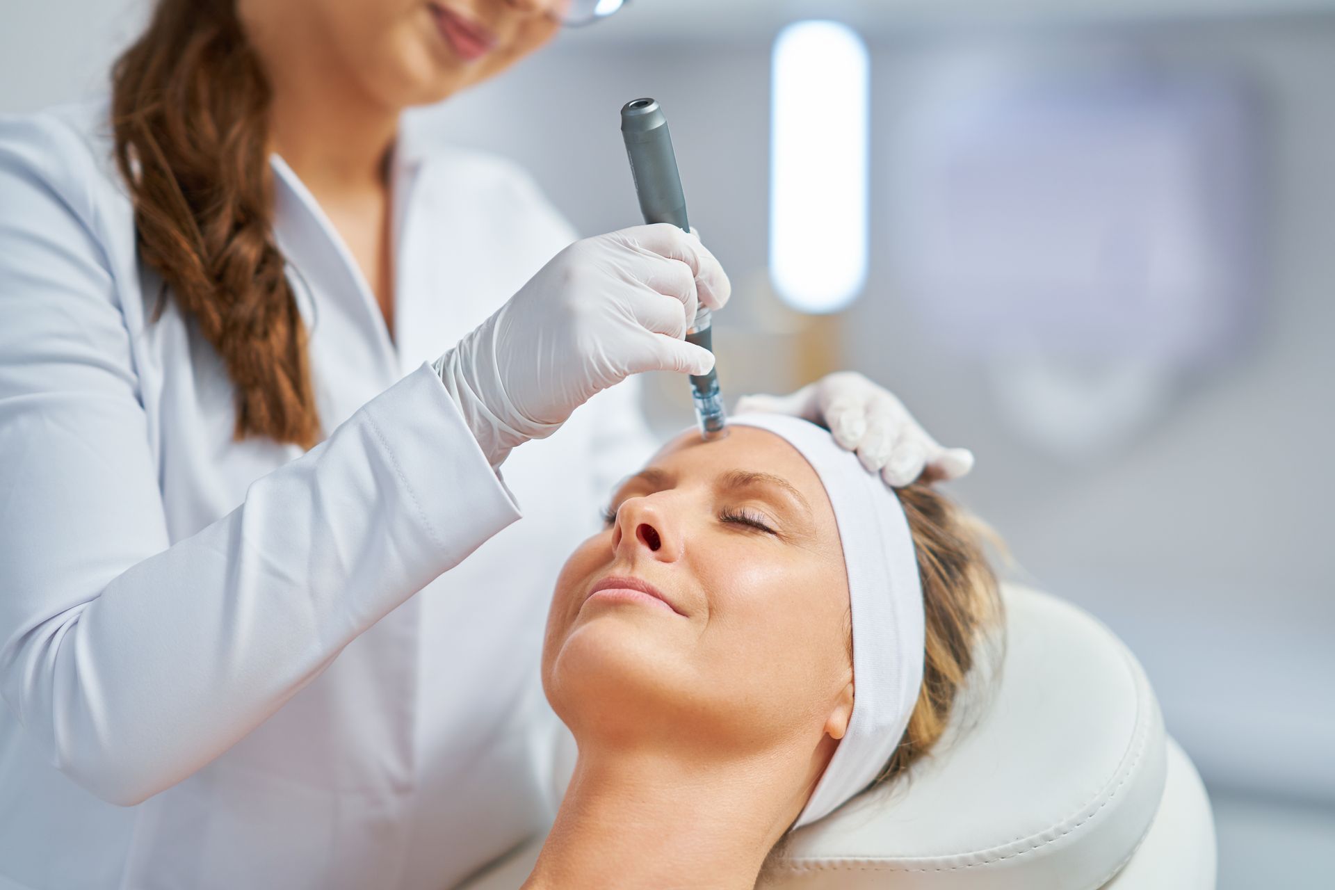 woman in beauty salon getting microneedling treatment