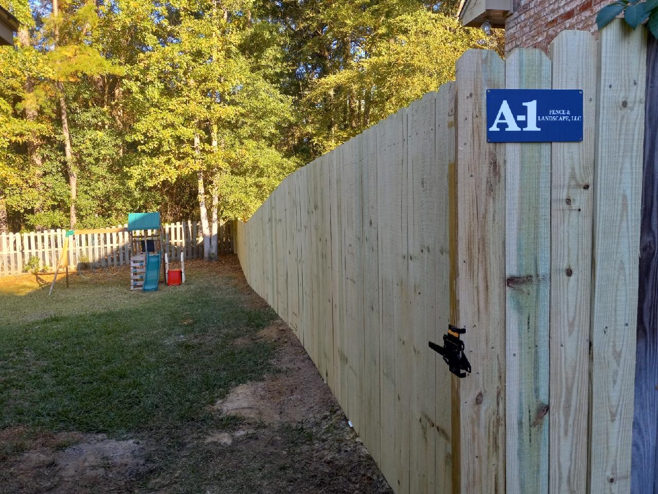 Wooden privacy fence with play place in back yard