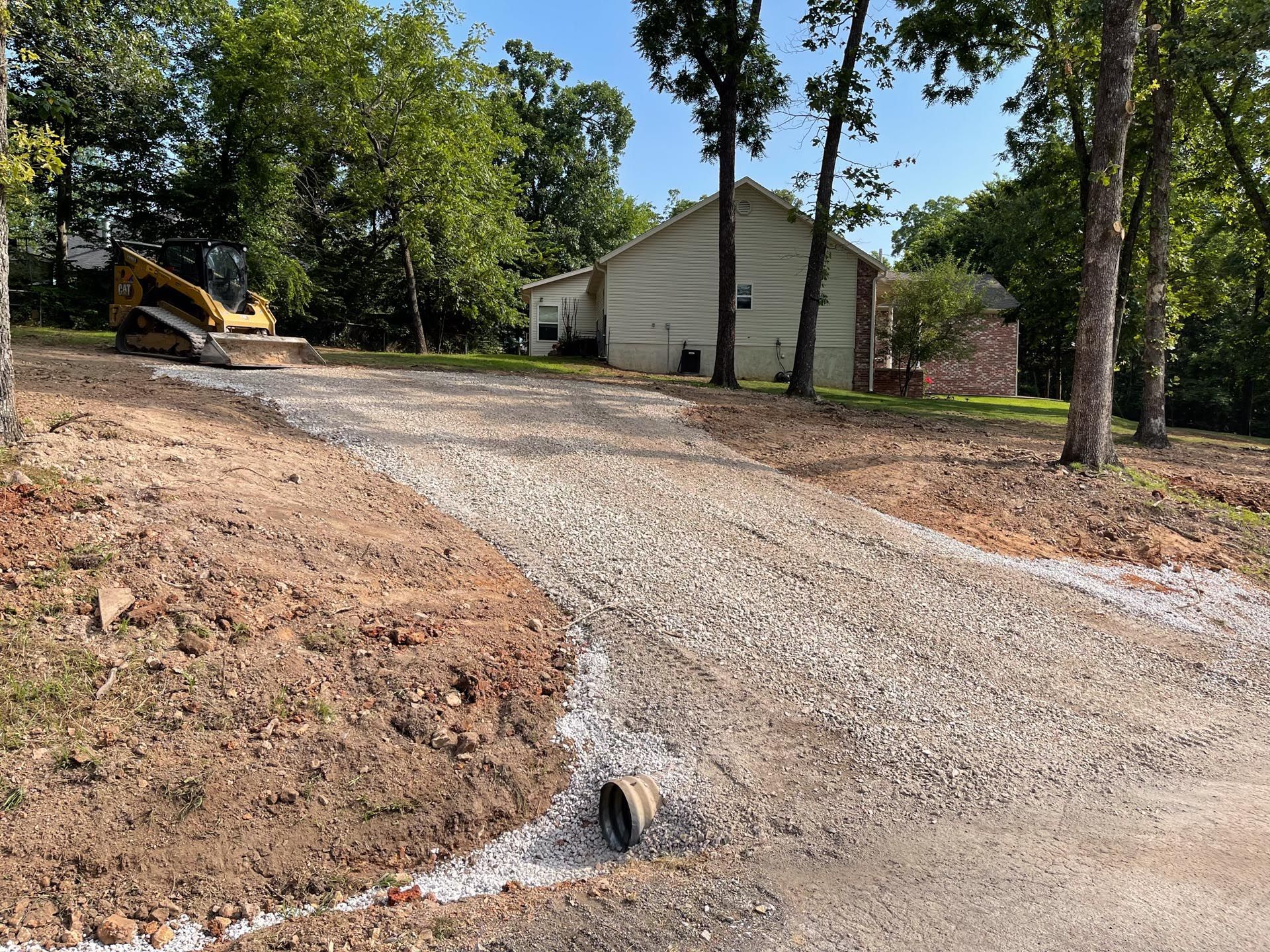 A pile of gravel is sitting in the middle of a dirt field.