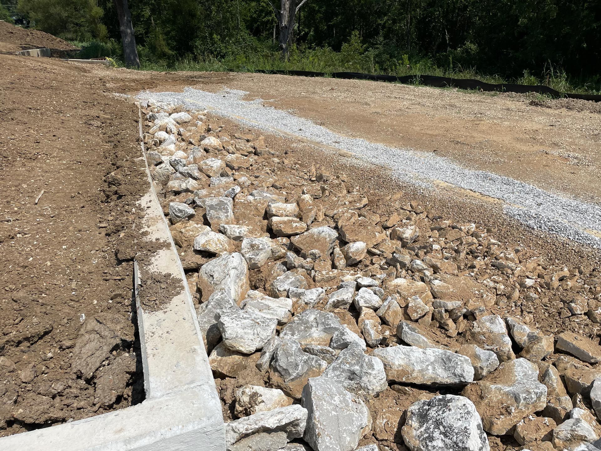 A pile of rocks is sitting on top of a dirt road.