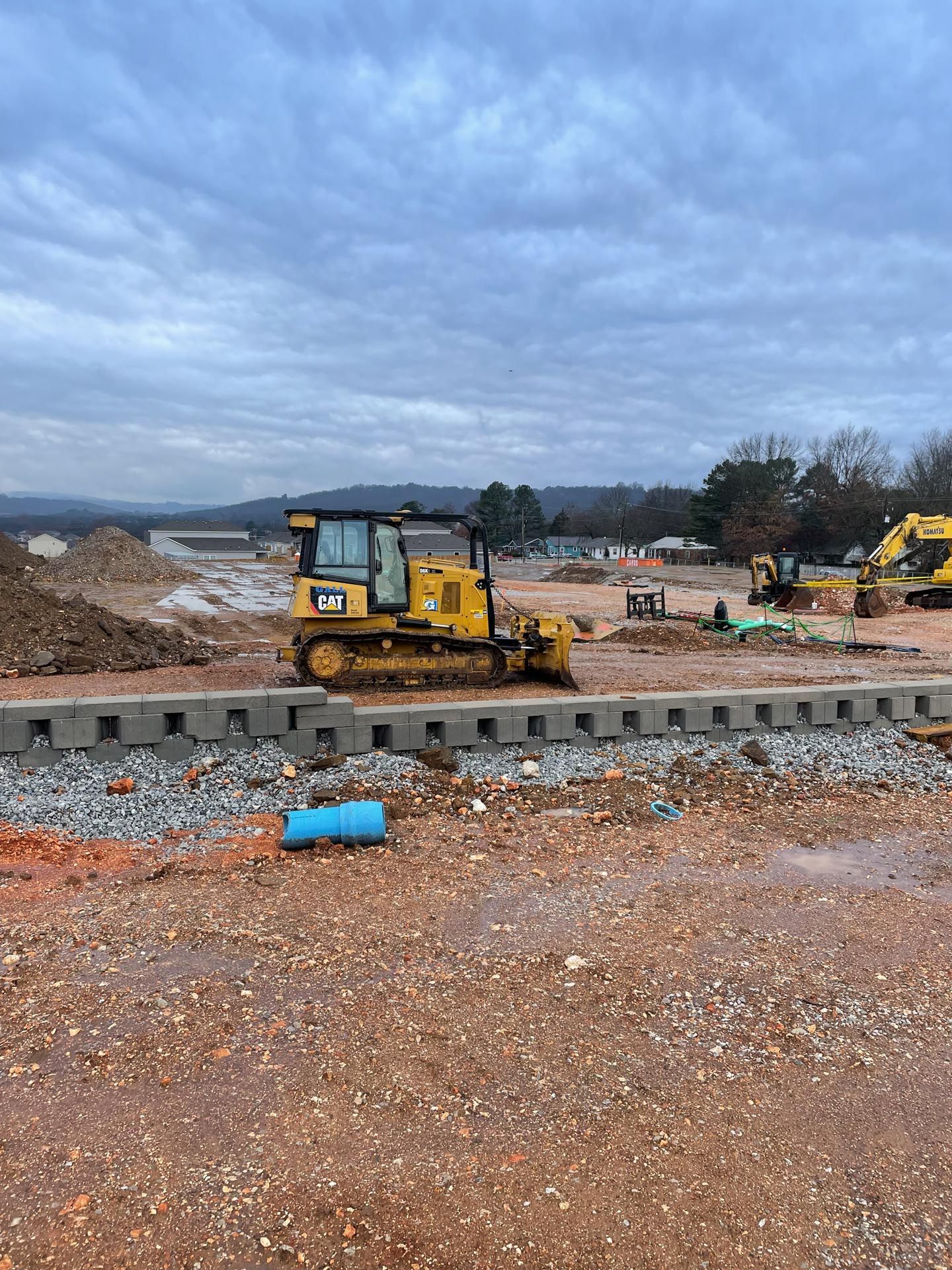 A yellow bulldozer is sitting on top of a dirt field.