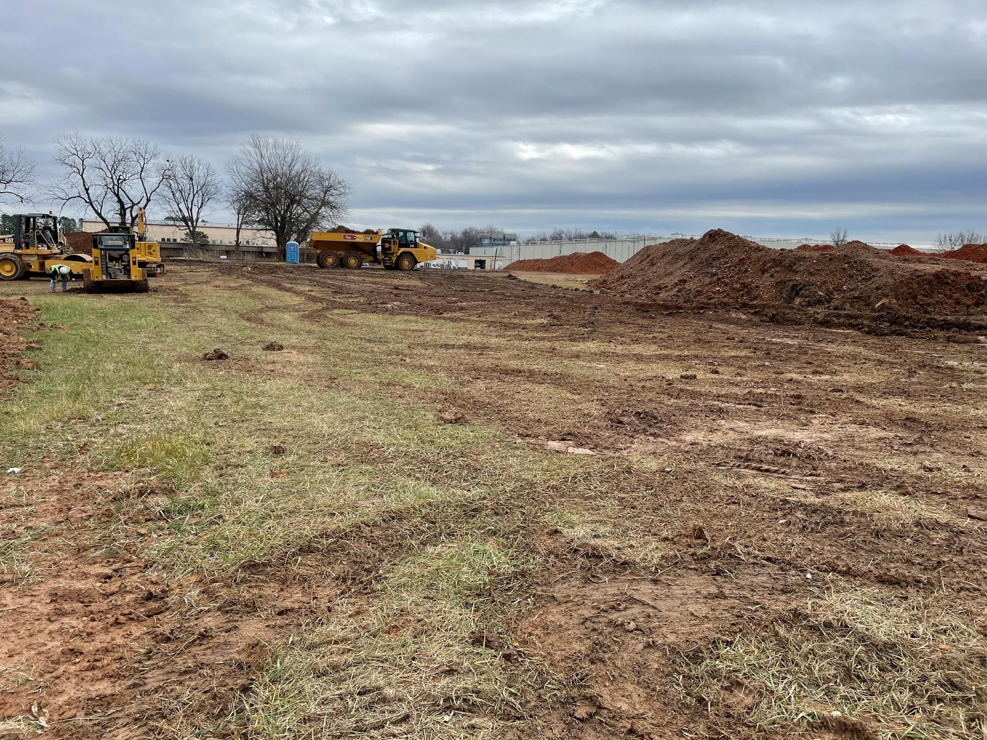 A large dirt field with a lot of machinery in it.