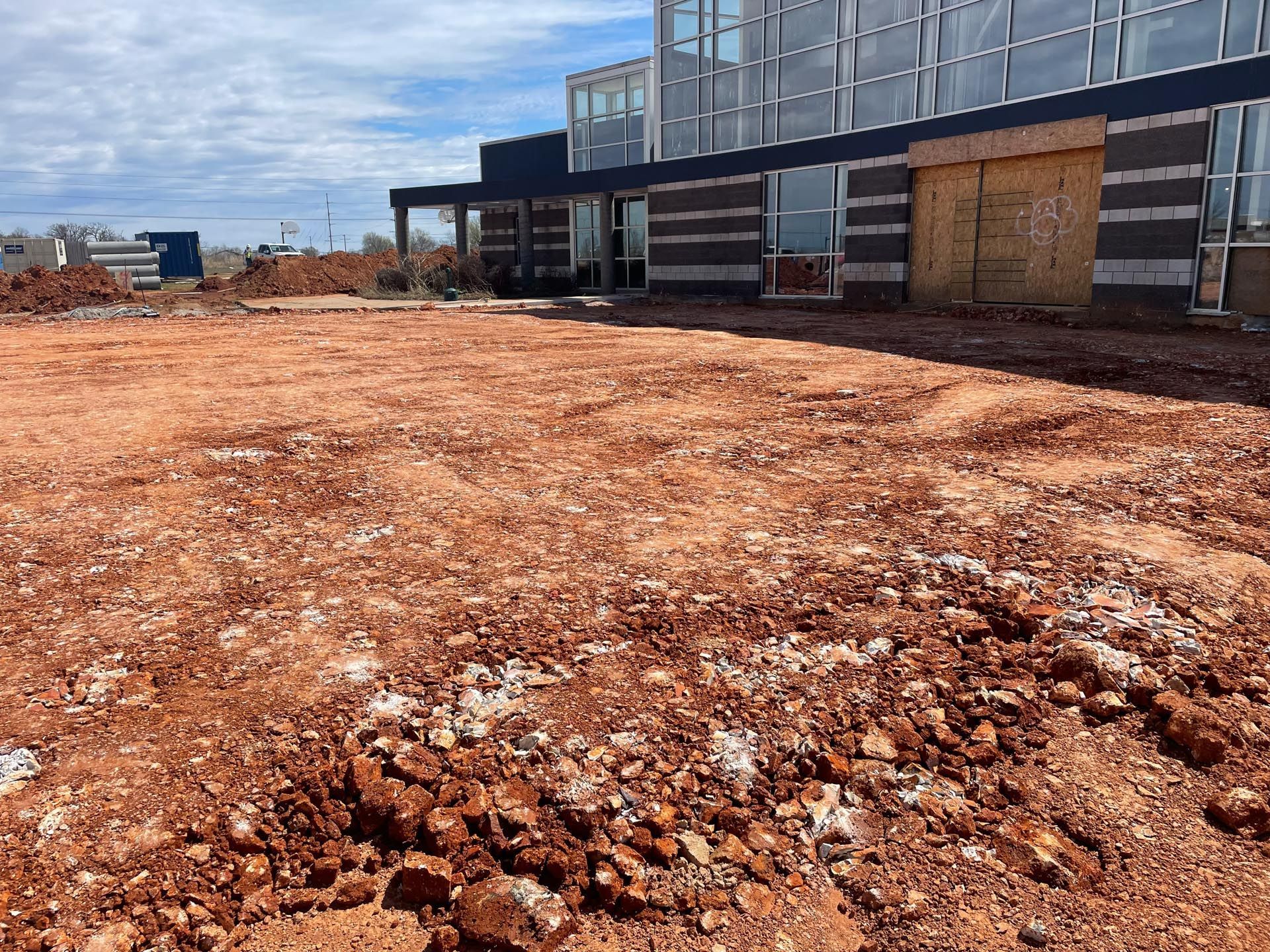 A large building under construction with a lot of dirt in front of it.