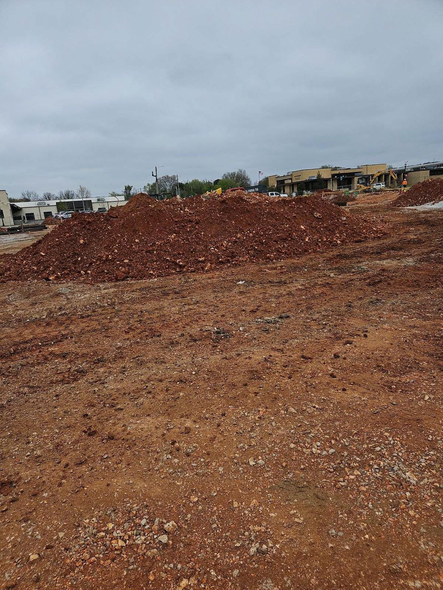 There is a large pile of dirt in the middle of the field.