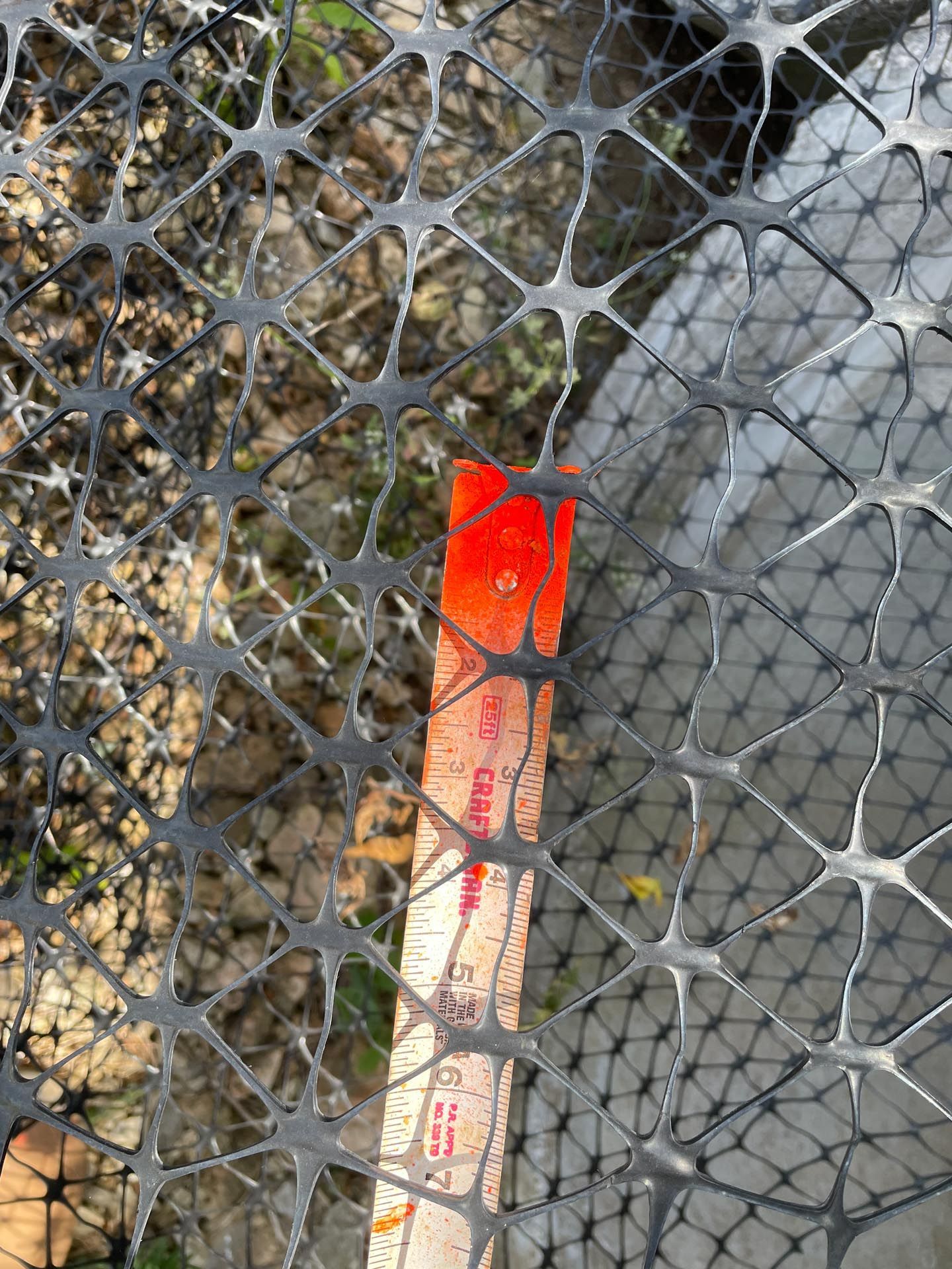 A fishing net with a ruler sticking out of it.