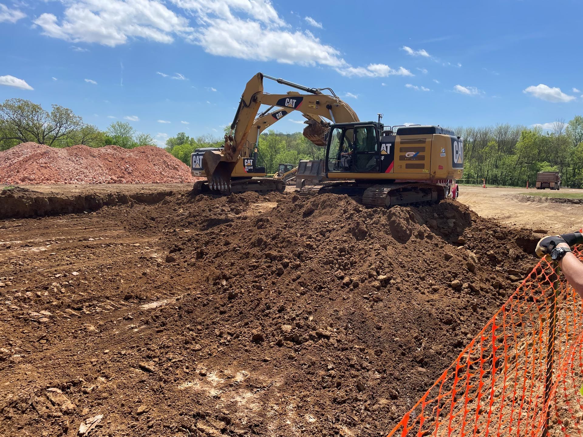 A large excavator is digging a hole in a dirt field.