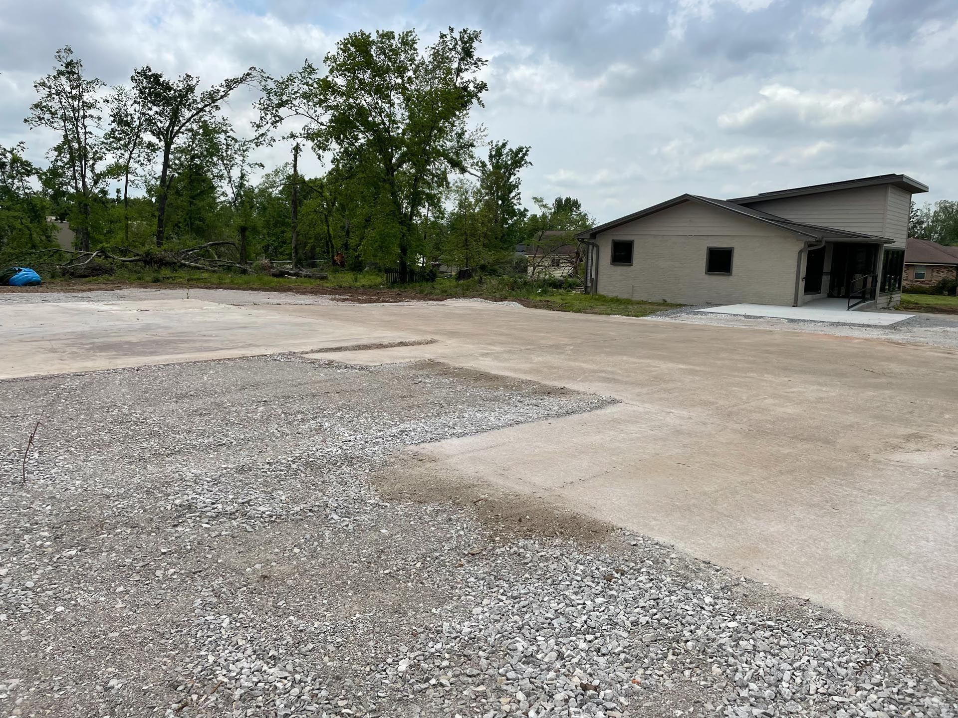 A large gravel area with a house in the background