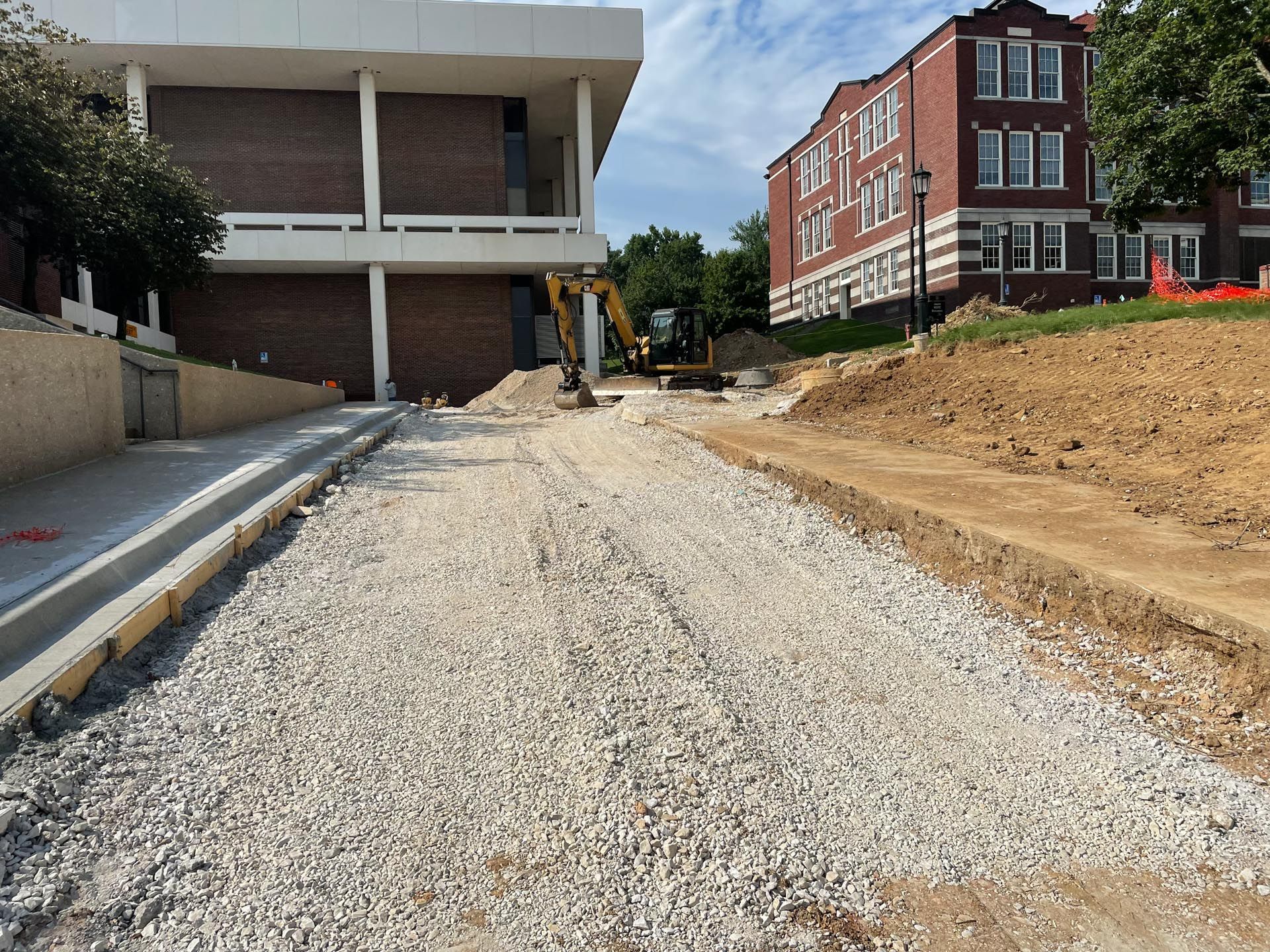 A construction site with a large brick building in the background