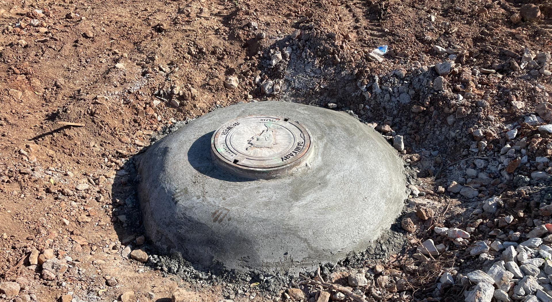 A concrete object is sitting on top of a pile of dirt.