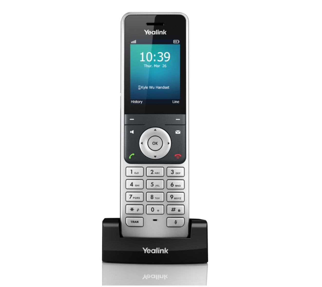 A yealink phone is sitting on a charging dock on a white background.