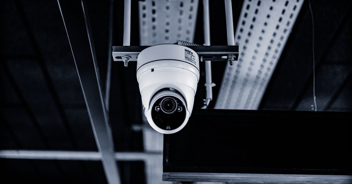 A security camera is hanging from the ceiling of a building.