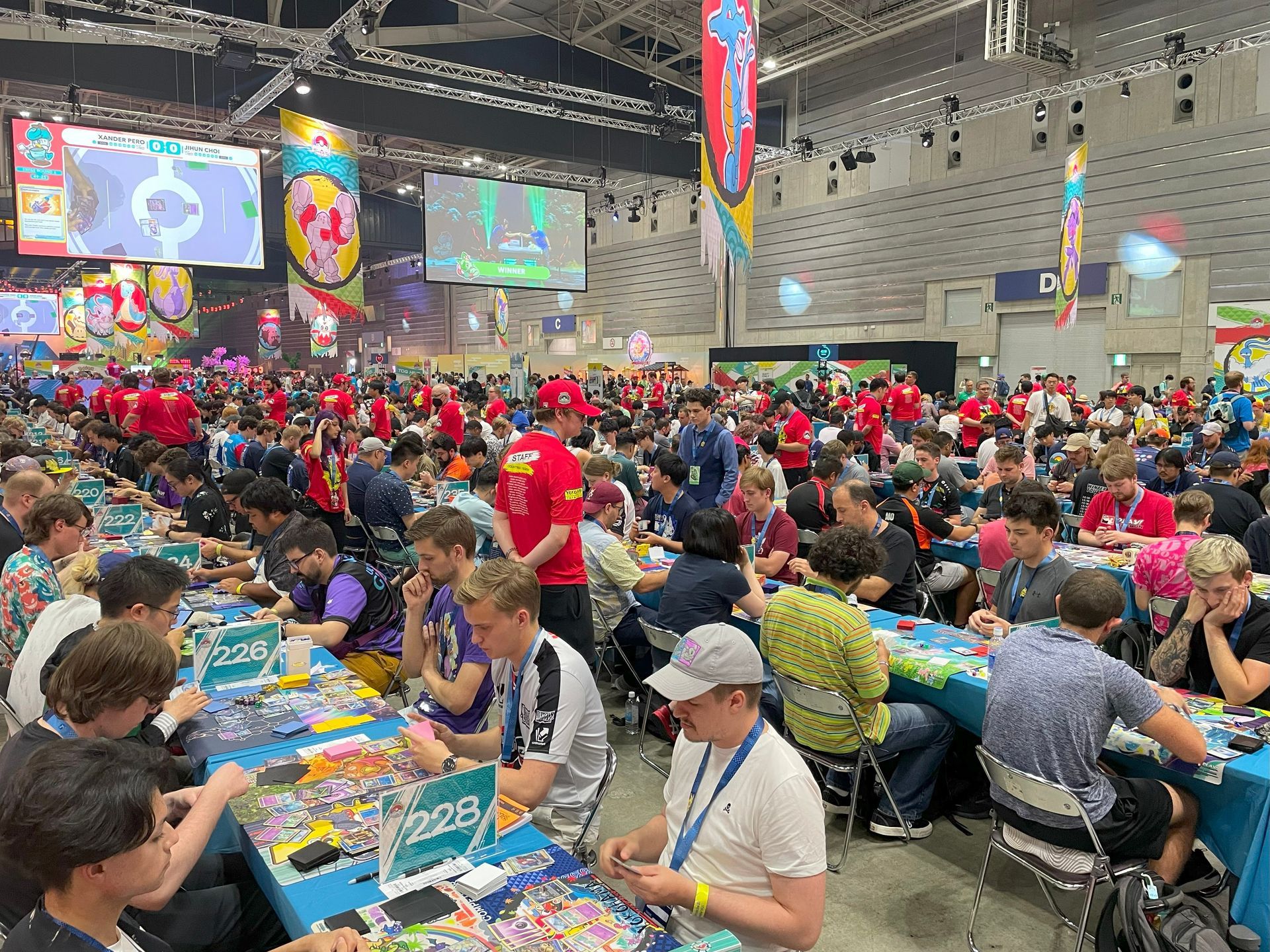 A large group of people are sitting at tables in a large room.