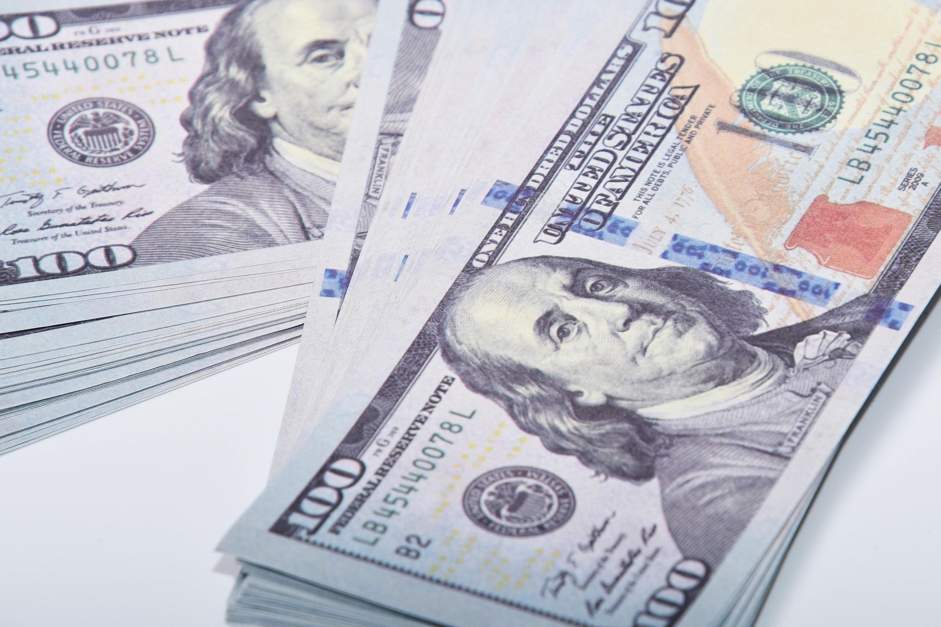 Stacks of US $100 bills, showing Benjamin Franklin's face.