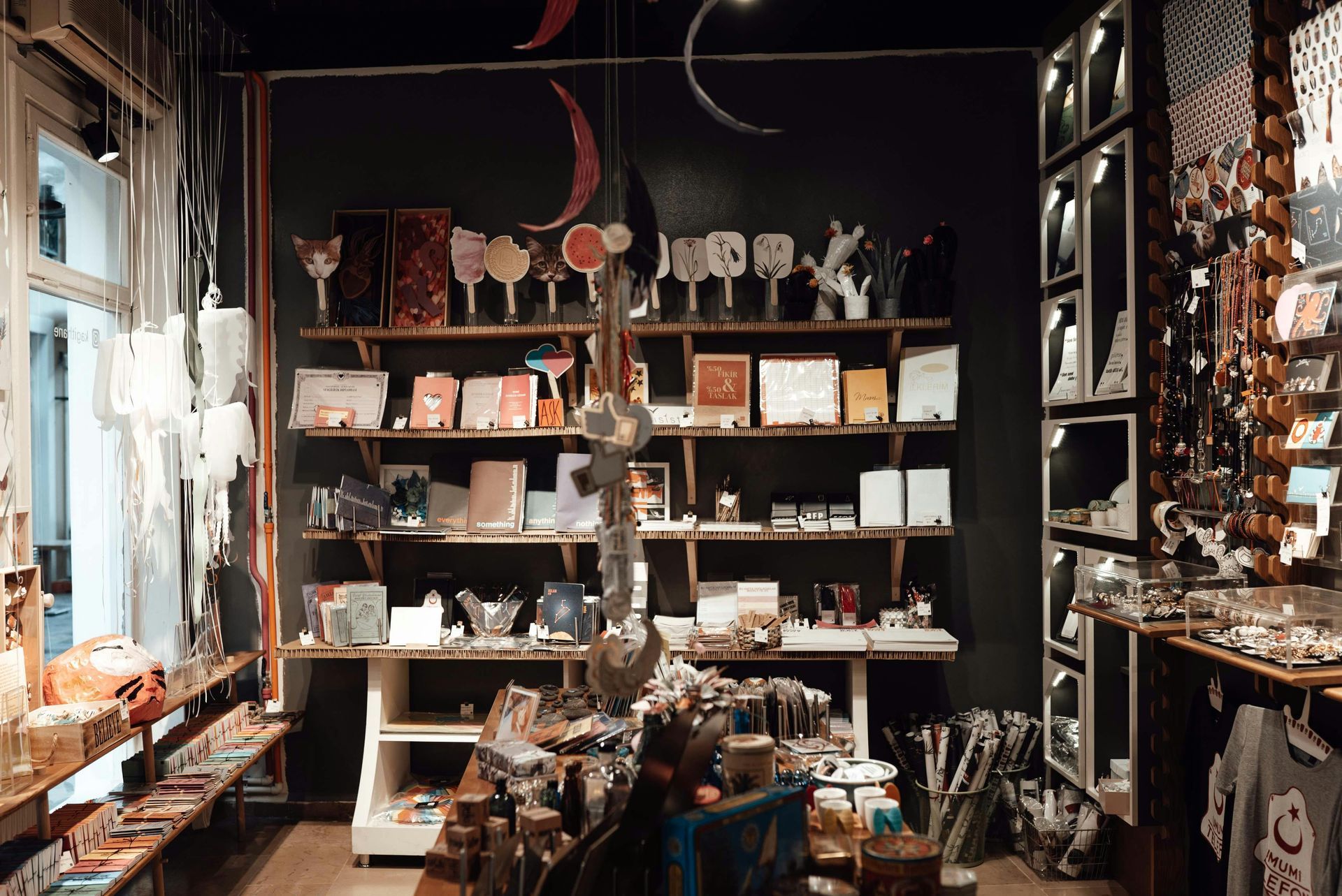 Interior of a shop filled with shelves displaying various items, including art, jewelry, and gifts.