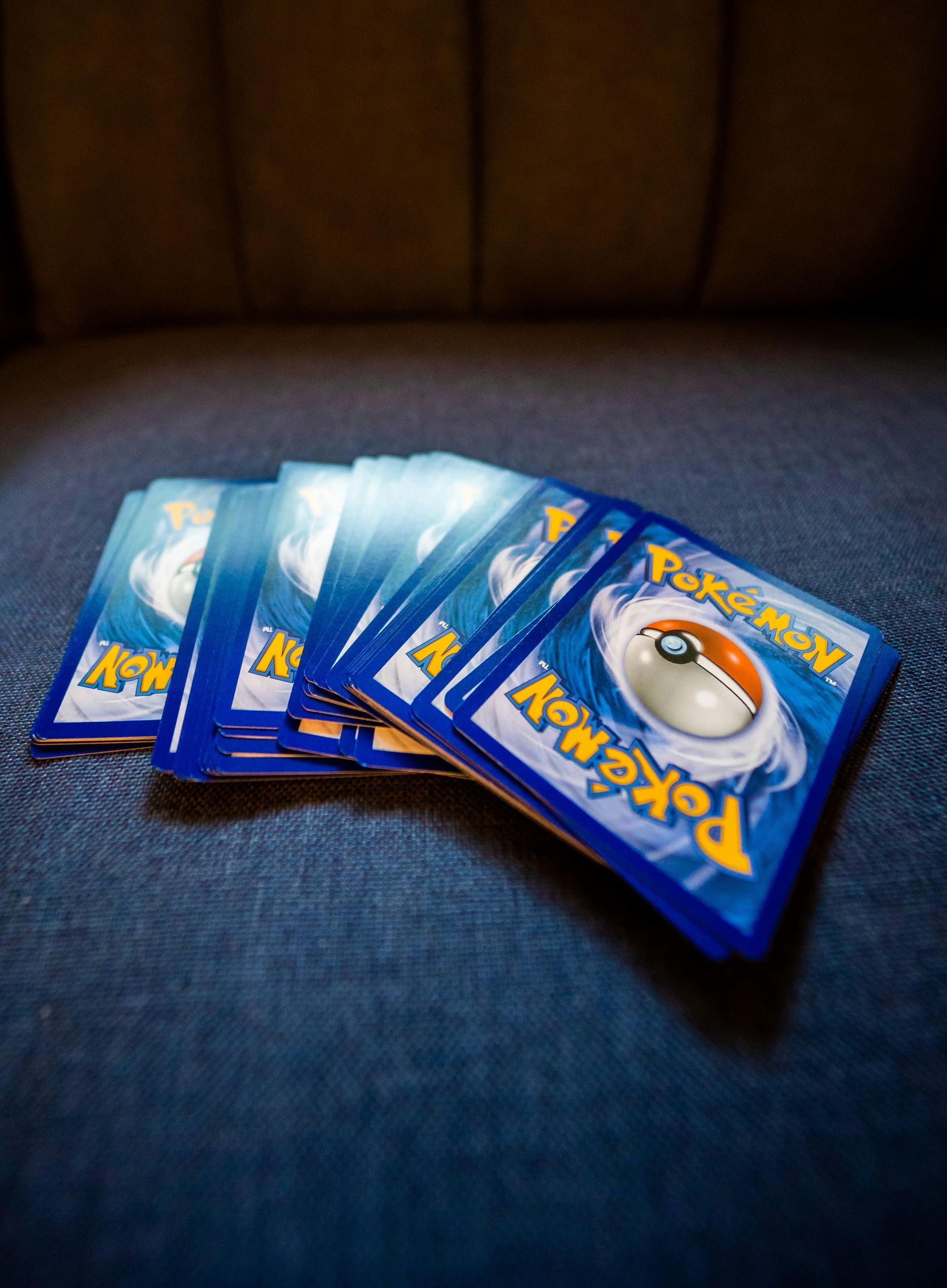 A bunch of pokemon cards are stacked on top of each other on a table.