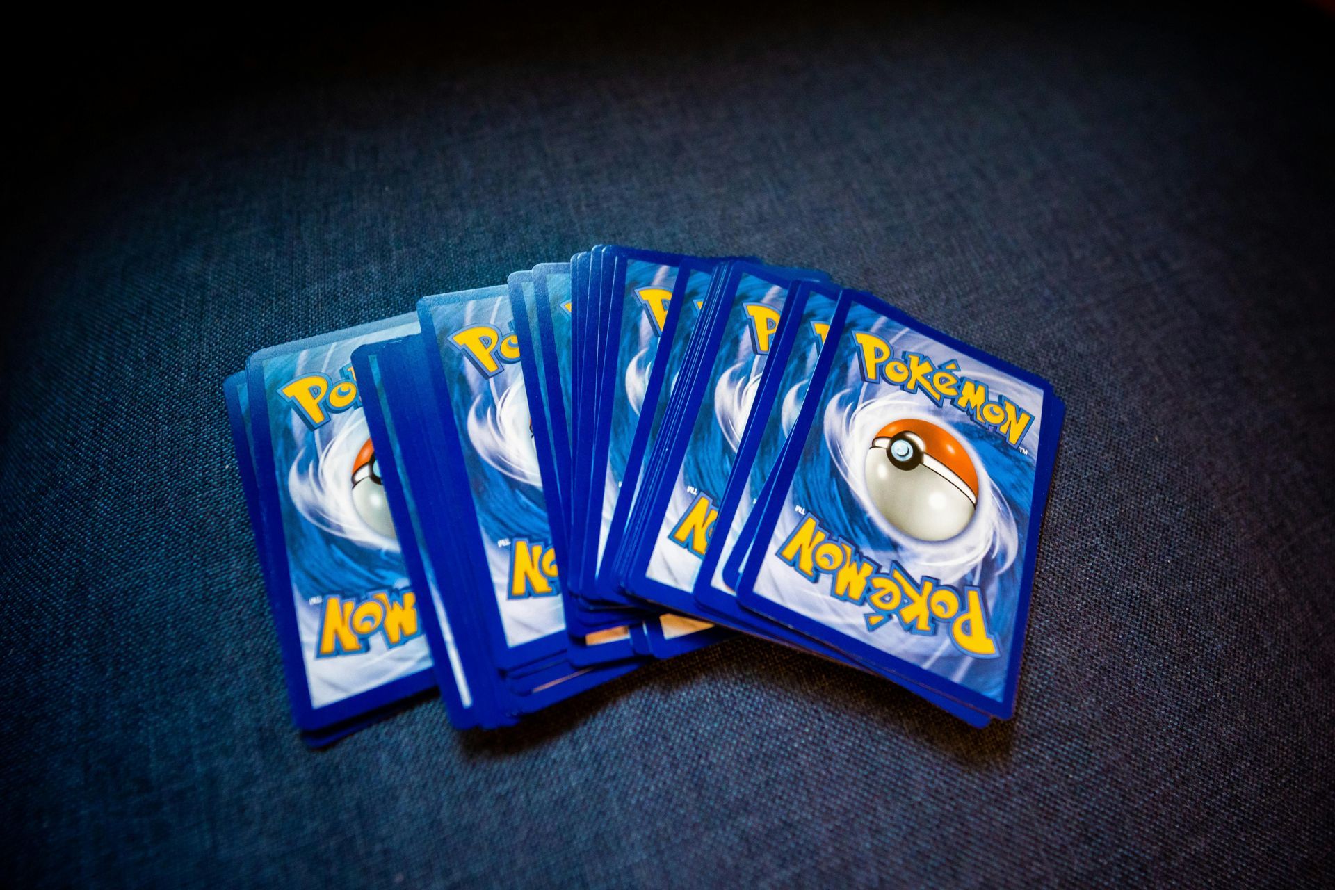 A bunch of pokemon cards are stacked on top of each other on a table.