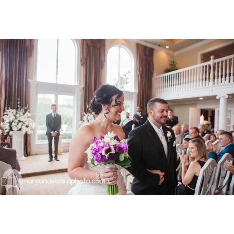 A bride and groom are walking down the aisle at their wedding ceremony.