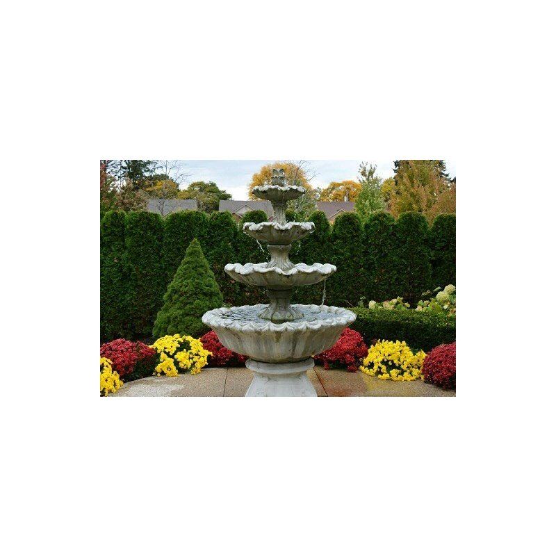 A fountain in a garden surrounded by flowers and bushes.