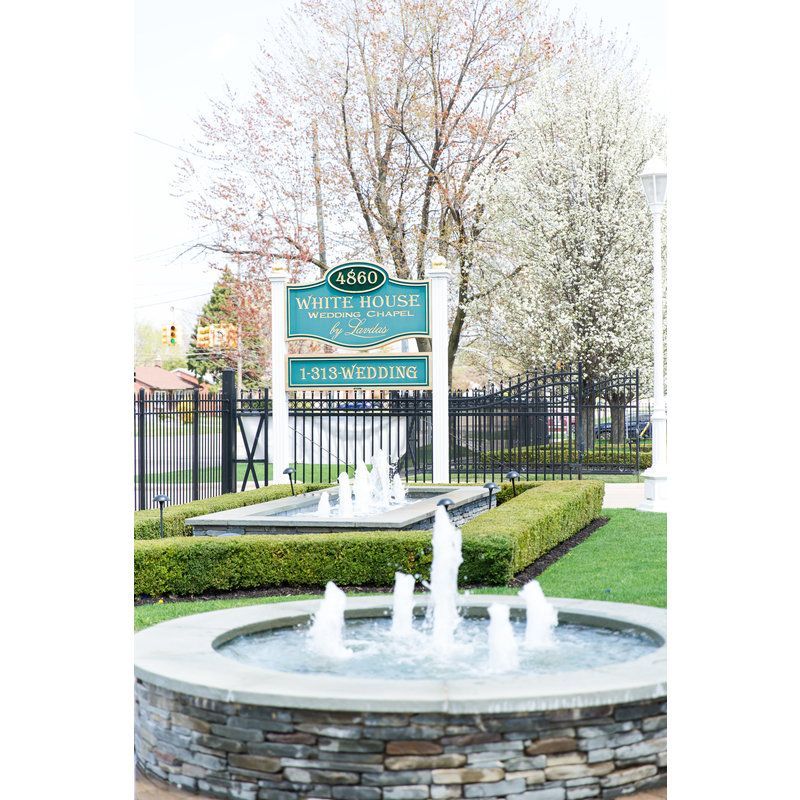 There is a fountain in front of a sign that says white house.