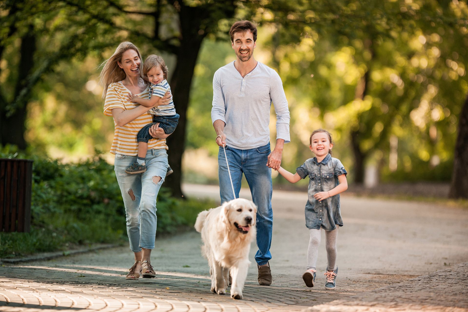A family is walking a dog in a park.