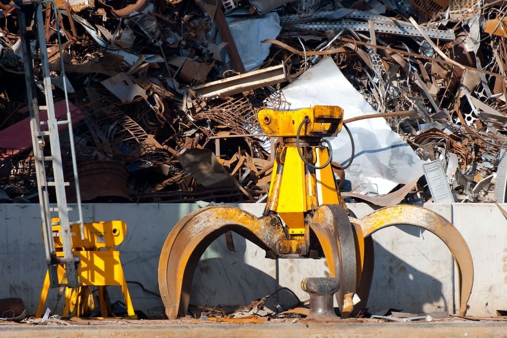 A Yellow Crane Is Sitting In Front Of A Pile Of Scrap Metal — Caloundra Scrap Metal in Landsborough, QLD