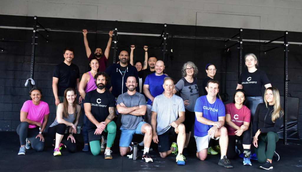 A group of people are posing for a picture in a gym.