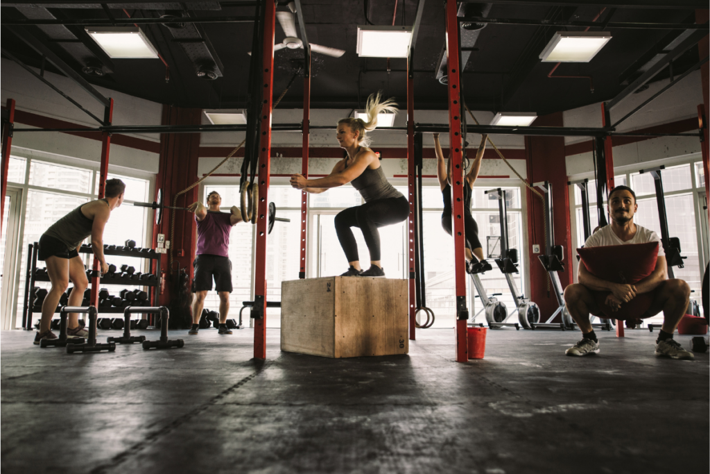 A group of people are doing exercises in a gym.