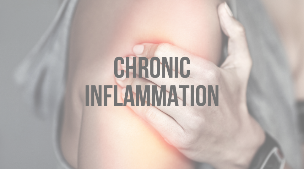 A person is holding their arm in pain because of chronic inflammation.