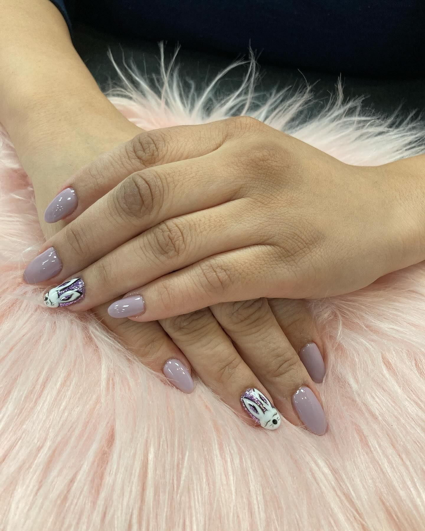 Hands with mauve almond-shaped nails, one with white and black floral design.