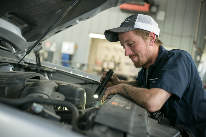 Mechanic at work on hood of car | Grahams Auto & Truck Clinic