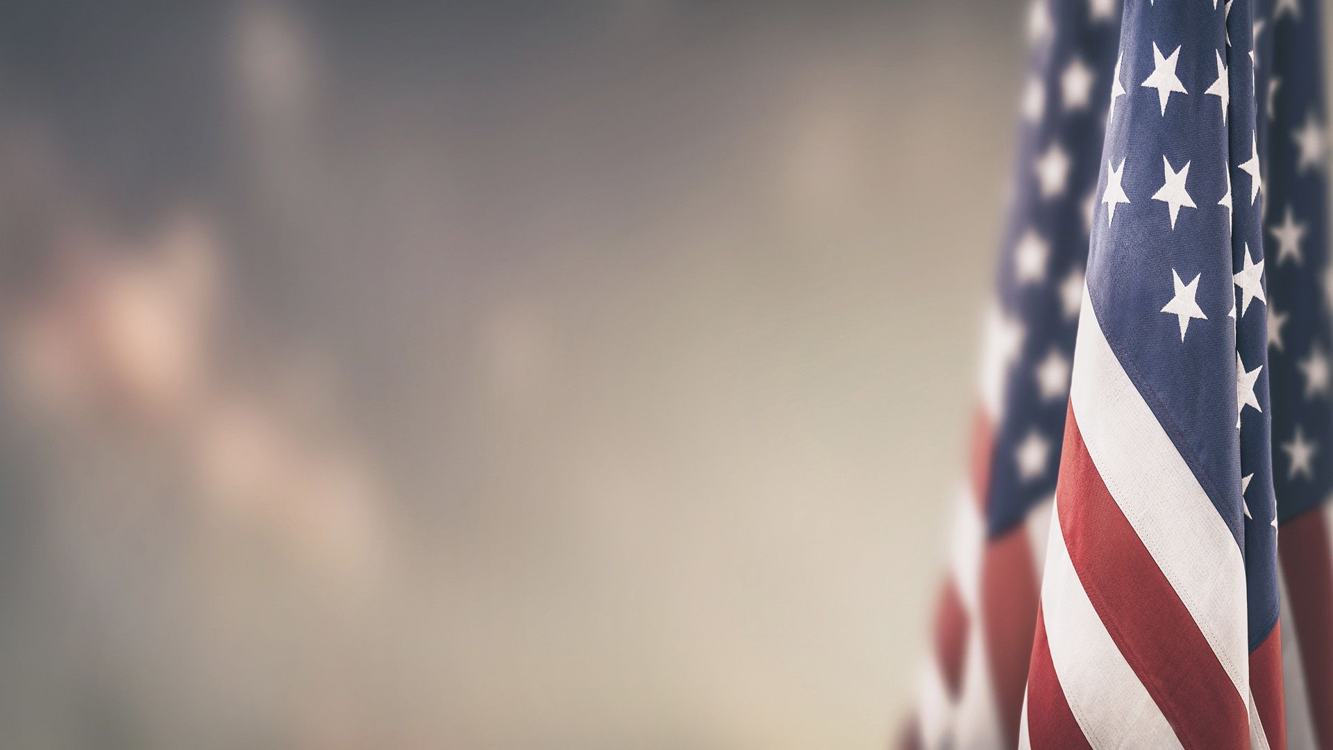An elderly couple is sitting at a table with a laptop and a notebook.