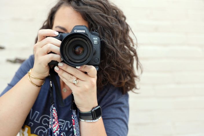 A woman is taking a picture with a canon camera.