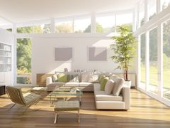 A living room with a couch , chair , coffee table and lots of windows.