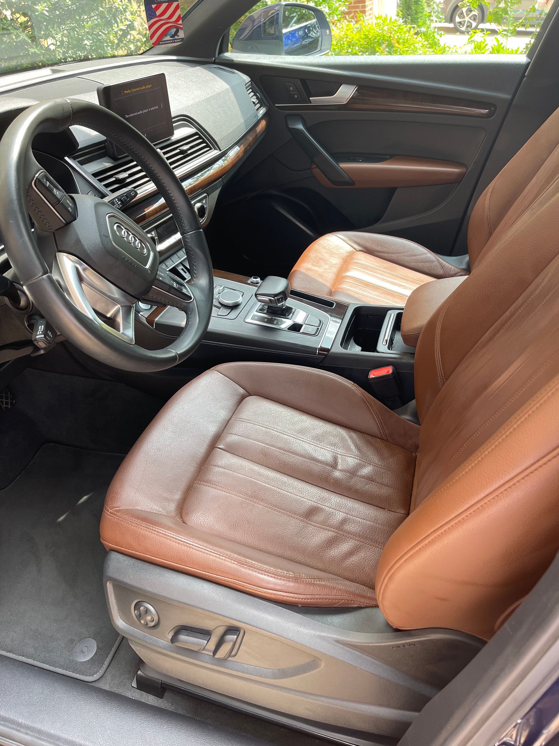 Close-up of detailed car interior with deep-cleaned leather, refreshed trim, and a clean center console and cup holders.
