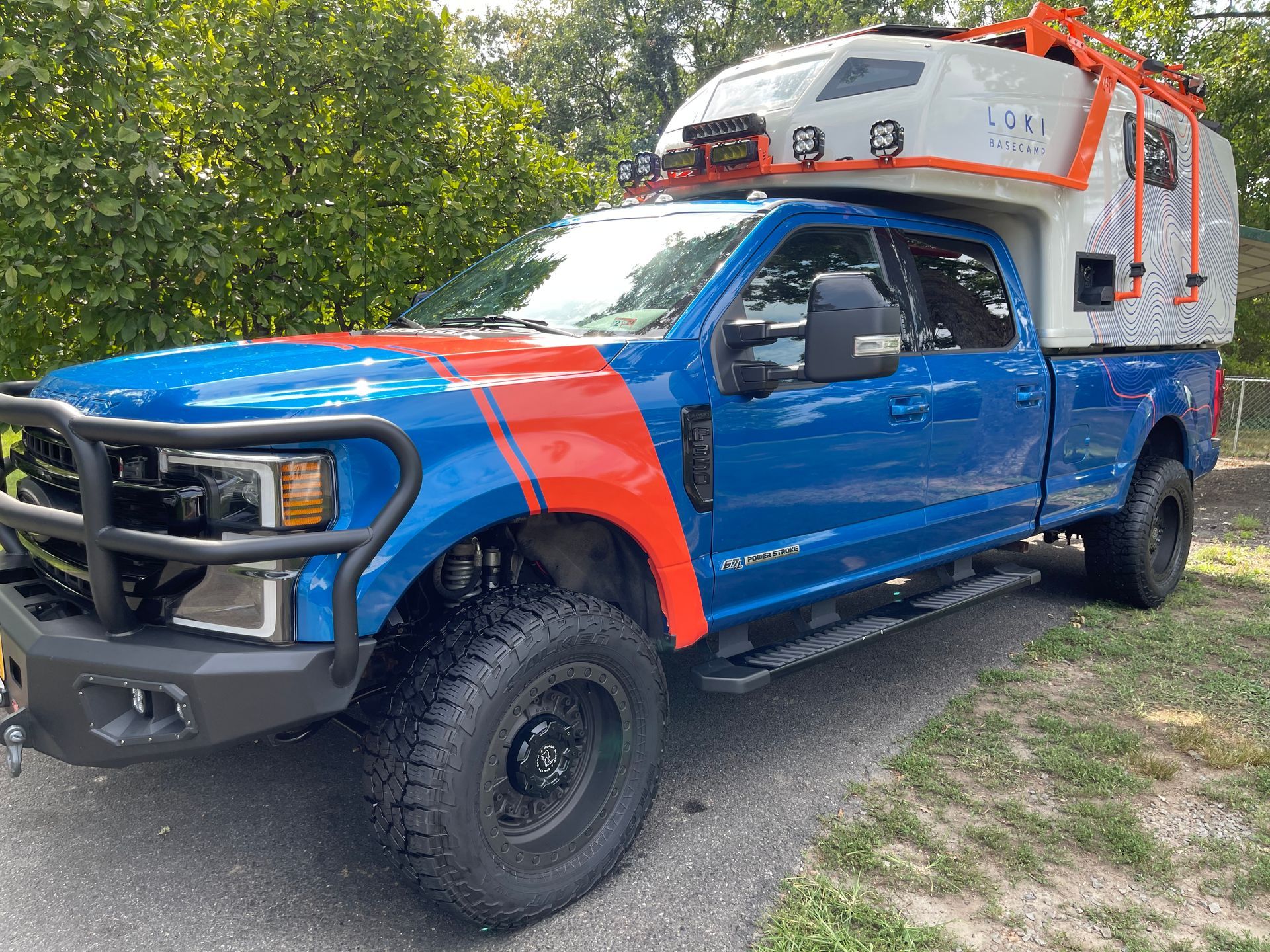 Blue Ford F-250 Super Duty overland truck with camper, clean paint and wheels following professional truck detailing