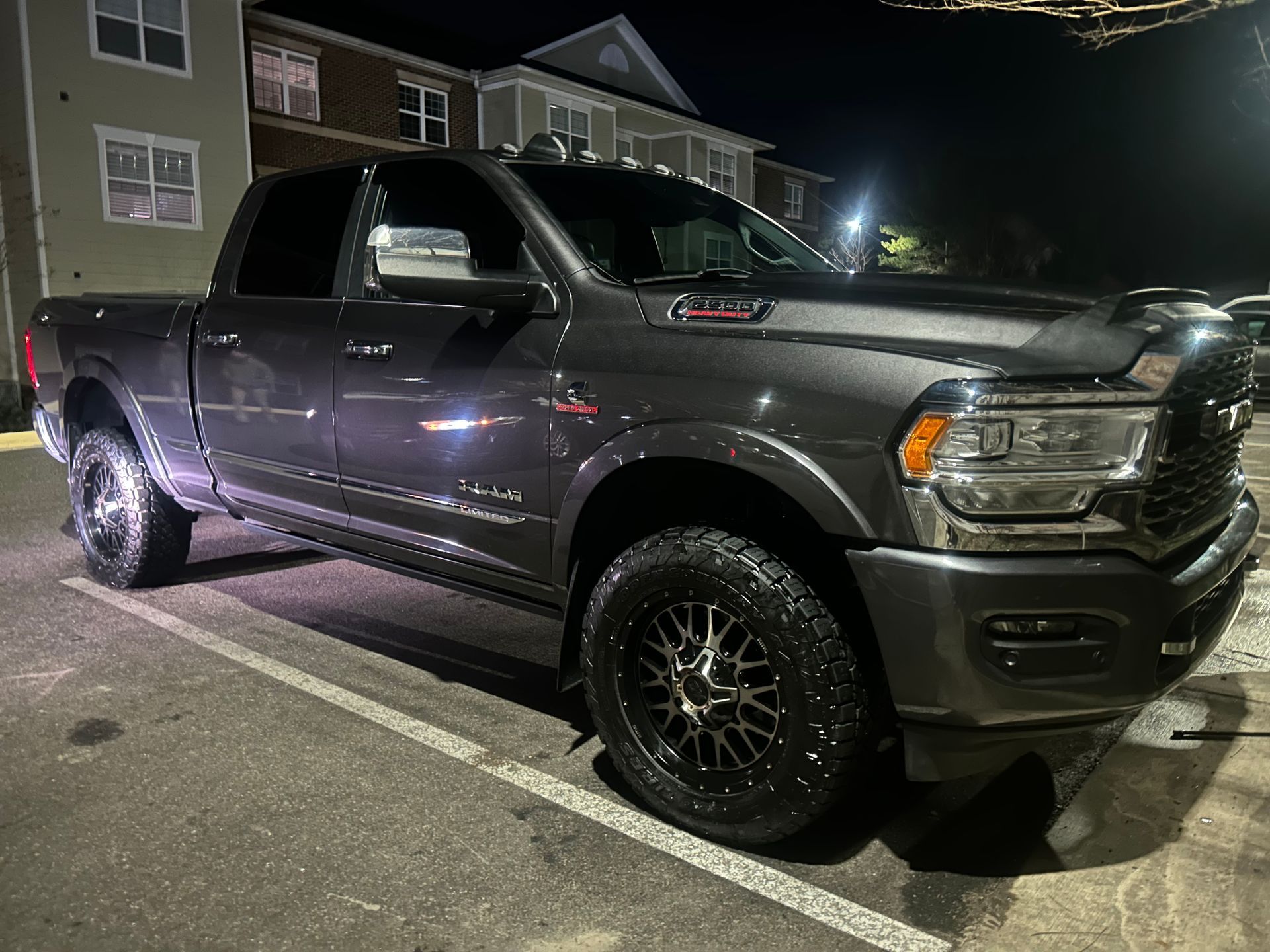 Dark gray Ram 2500 pickup truck at night with clean paint, detailed wheels, and restored exterior finish