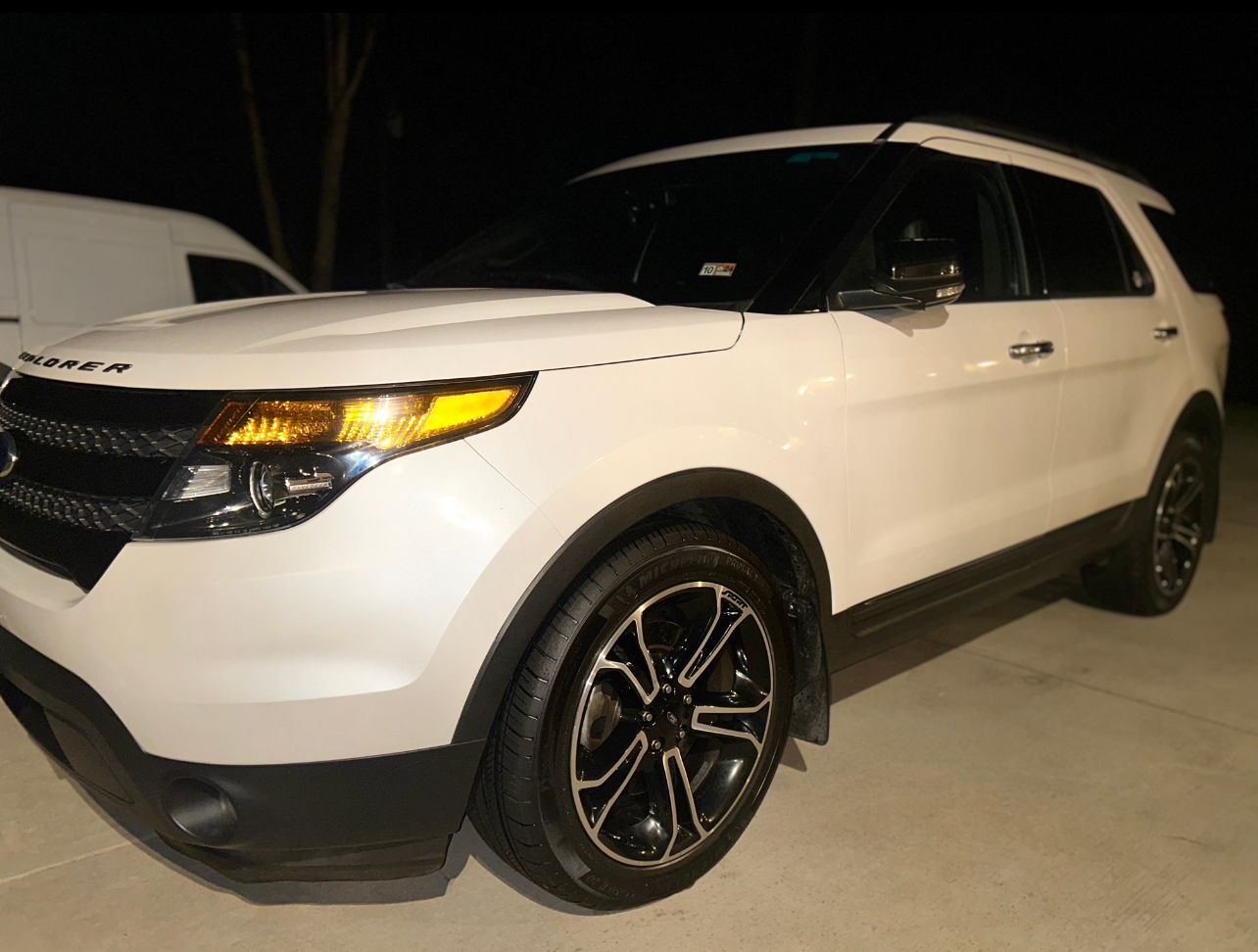 White Ford Explorer SUV photographed at night with clean paint, glossy wheels, and restored exterior finish after detailing